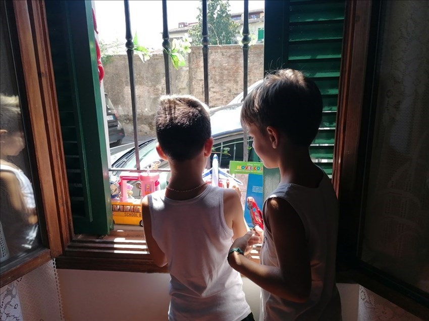 Jacopo con un suo amichetto mentre rifornisce la finestra con i giocattoli donati