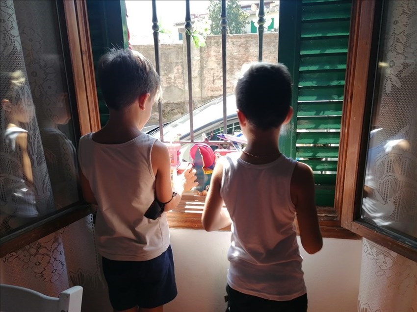 Jacopo con un suo amichetto mentre rifornisce la finestra con i giocattoli donati