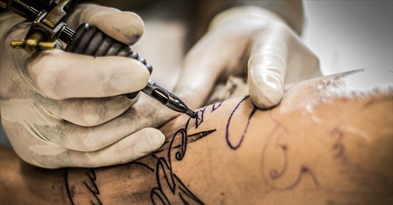 Un tatuatore al lavoro