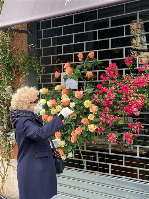 una signora coglie un fiore