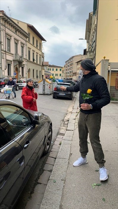 Alessandro dona un fiore ai passanti