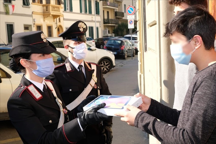 Carabinieri consegnano tablet a un giovane studente