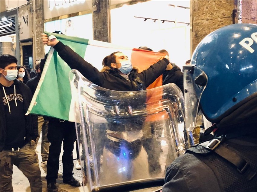 Manifestante che alza al cielo la bandiera italiana