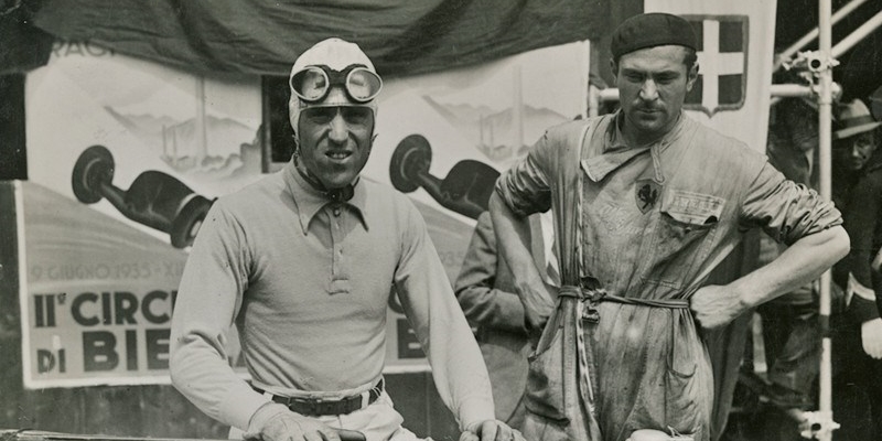 Auguri Tazio Nuvolari. Da sinistra: Nuvolari. Qui insieme a un meccanico della Scuderia Ferrari posano accanto all'Alfa Romeo Tipo B P3 ""Sport"" in occasione del vittorioso Circuito di Biella 1935