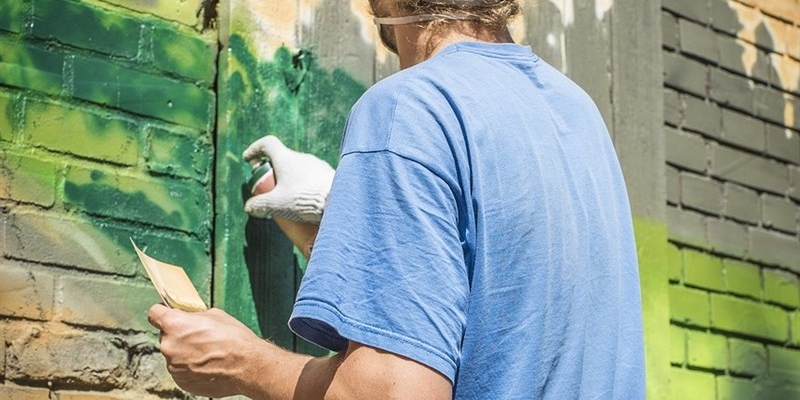 Scrive con lo spray sul muro