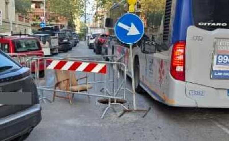 Il pericoloso tombino scancato da un bus con la sua poltrona ""d'attesa"" di fianco.