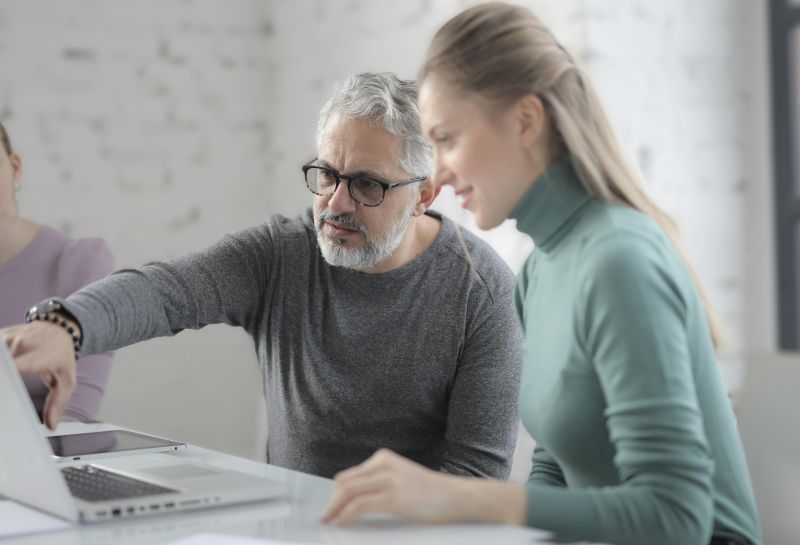 Un utente davanti al computer aiutato da una giovane operatrice A uso gratuito Pexels